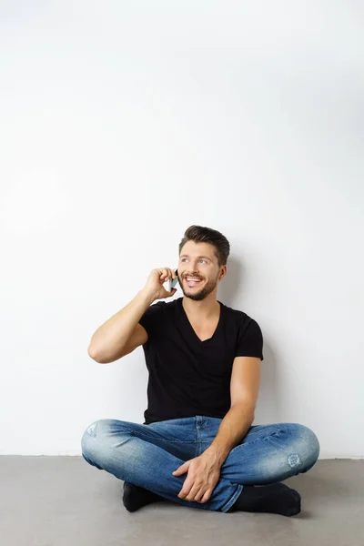 Man zit op vloer praten over telefoon — Stockfoto