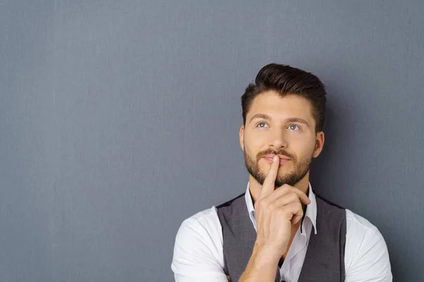 Thoughtful man with his finger to his lips — Stock Photo, Image