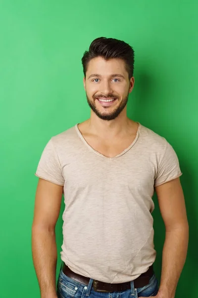 Sonriente joven posando sobre fondo verde — Foto de Stock