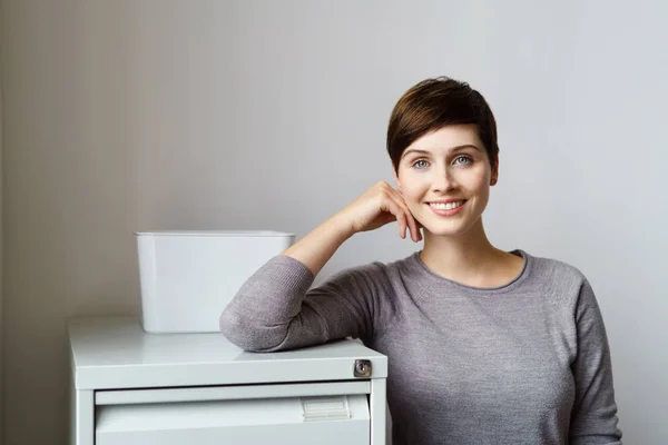 Junge fröhliche Frau lehnt an Aktenschrank — Stockfoto