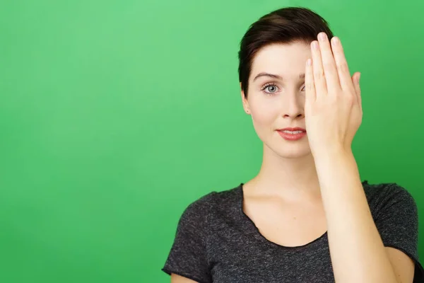 Mujer joven cubriéndose el ojo con la mano —  Fotos de Stock