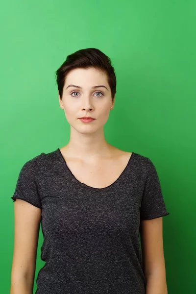 Jeune femme debout sur fond vert — Photo