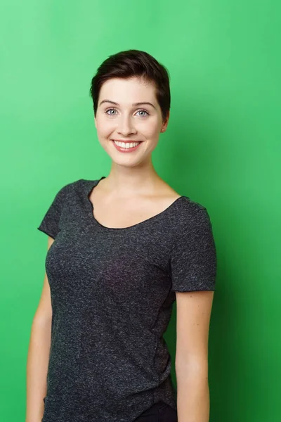 Lachende vrouw stond tegen een groene achtergrond — Stockfoto