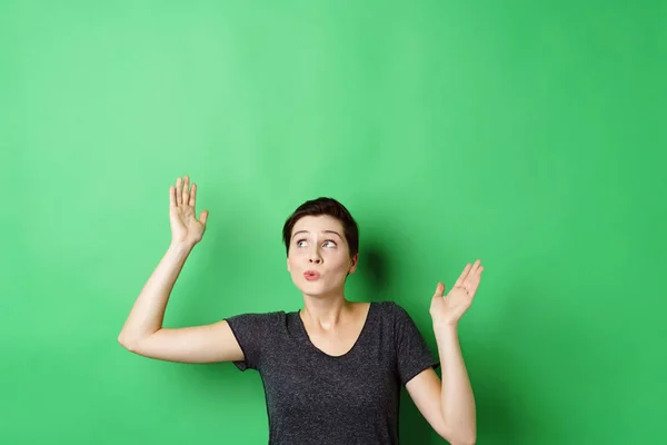 Vrouw met handen tegen groen scherm — Stockfoto