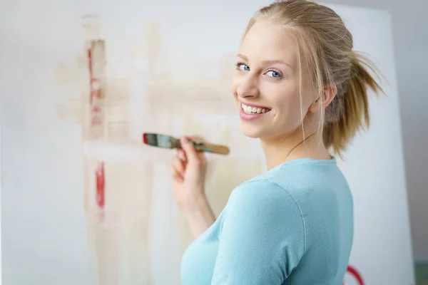 Mujer alegre pintura cuadro con pincel —  Fotos de Stock