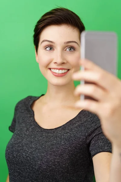 Fröhliche Frau blickt aufs Smartphone — Stockfoto