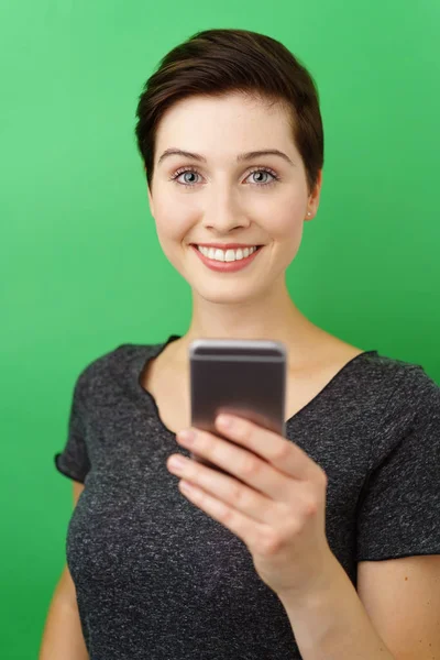 Uśmiechnięta kobieta ze smartfonu na zielonym tle — Zdjęcie stockowe