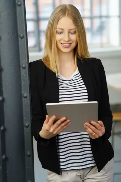 Mladá blond žena stojící s digitálním tabletu — Stock fotografie