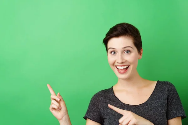 Lächelnde Frau zeigt auf leeren Raum — Stockfoto