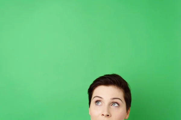 Joven mujer reflexiva sobre fondo verde — Foto de Stock