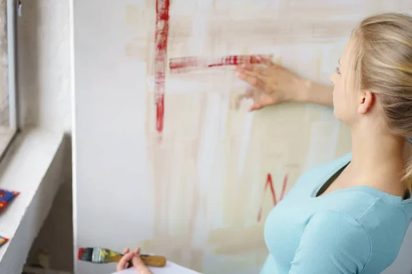 Blonde vrouw schilderij beeld in atelier — Stockfoto