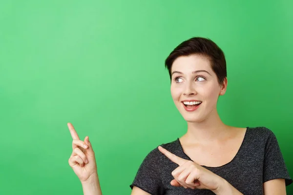 Femme joyeuse pointant vers l'espace de copie vide — Photo