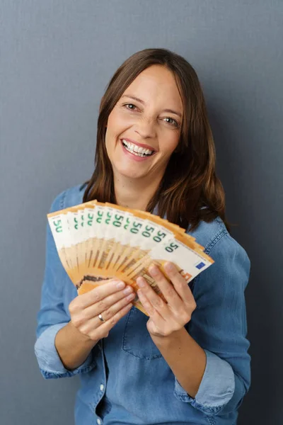 Mujer joven sosteniendo un paquete de billetes — Foto de Stock