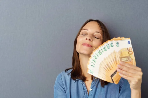 Mujer joven haciendo abanico de billetes de mano — Foto de Stock