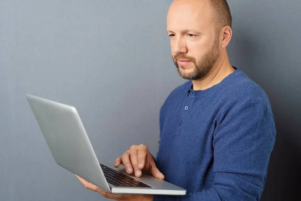 Człowiek stojący z otwartym laptopem — Zdjęcie stockowe