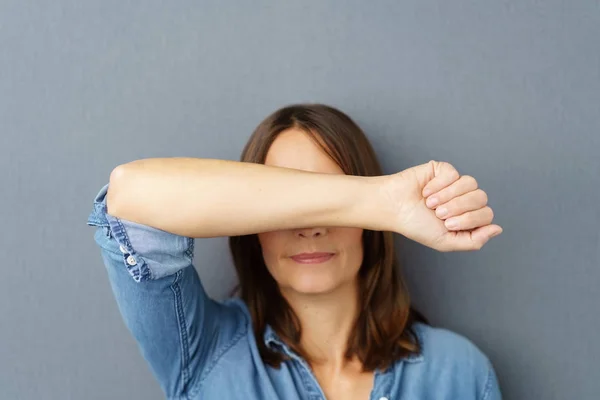 Vrouw die betrekking hebben op haar ogen met haar arm — Stockfoto