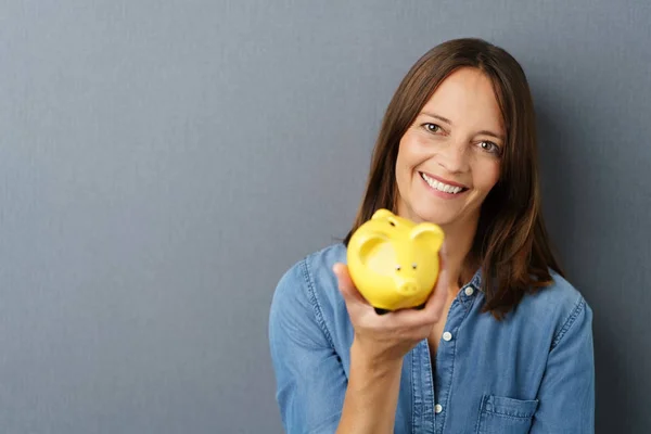 Jonge lachende vrouw met spaarvarken — Stockfoto