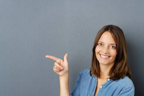 Happy pretty middle-aged woman pointing — Stock Photo, Image