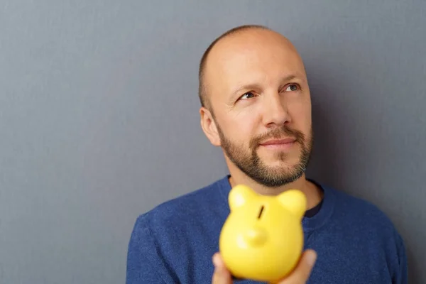 Man with piggy bank on grey background — Stock Photo, Image