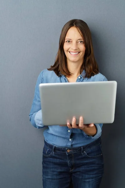 Mujer alegre de pelo largo de pie con el ordenador portátil — Foto de Stock