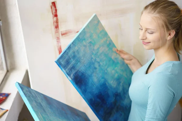 Young blonde woman painting in atelier — Stock Photo, Image