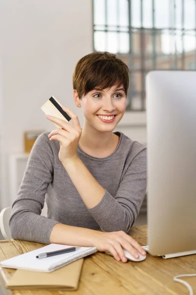 Vrouw die peinzend over krediet aankoop — Stockfoto