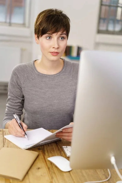 Wanita muda yang duduk di depan komputer — Stok Foto