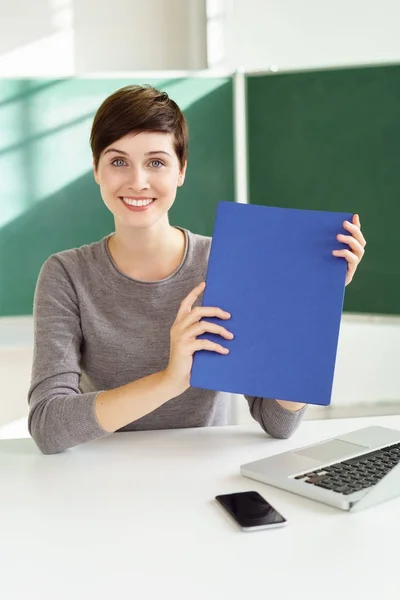Uśmiechnięta kobieta trzyma się niebieski folder — Zdjęcie stockowe
