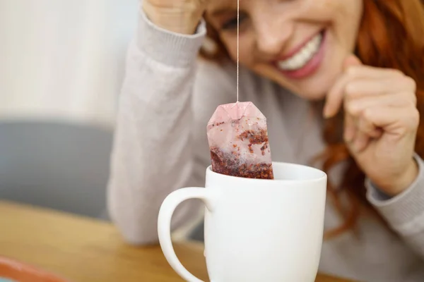 Mujer quitando la bolsa de té de la taza —  Fotos de Stock