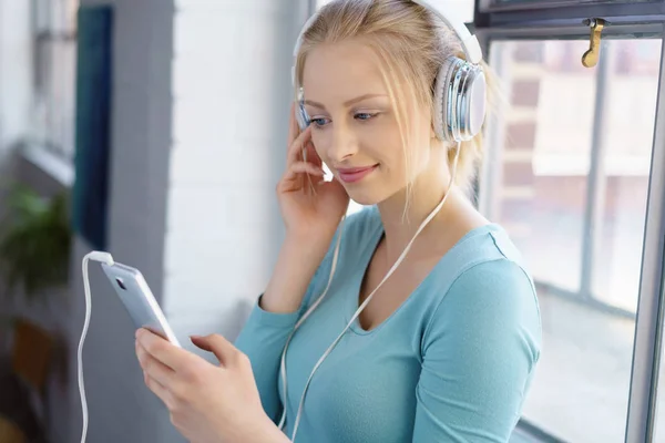 Leende kvinna lyssnar på musik — Stockfoto