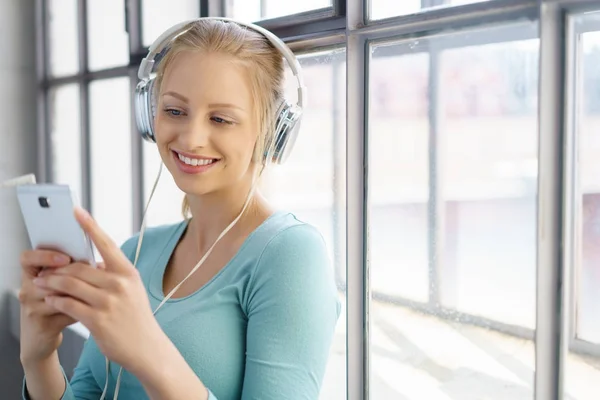 Femme souriante écoutant de la musique — Photo