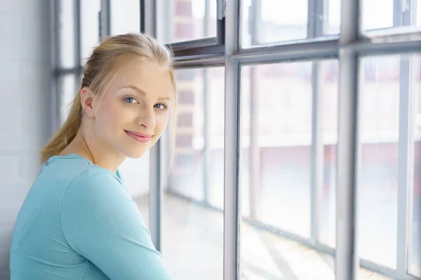 Mujer rubia de pie frente a la ventana —  Fotos de Stock