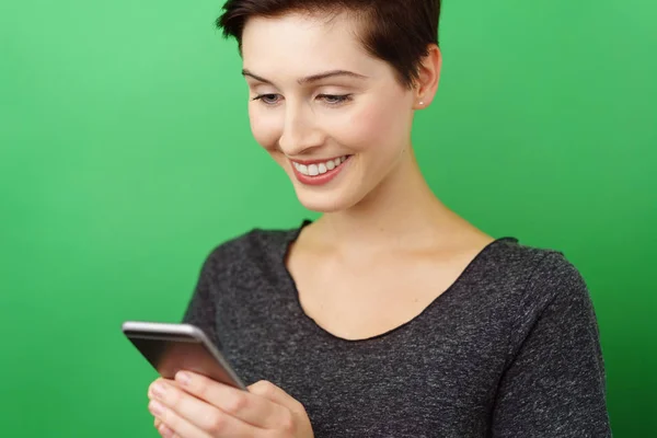 Młoda kobieta uśmiechający się z smartphone — Zdjęcie stockowe