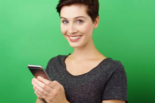Jeune femme souriante avec smartphone — Photo