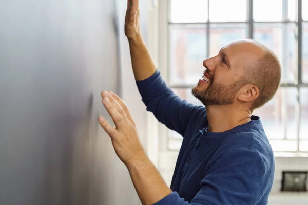Excited man looking at something on wall — Stock Photo, Image