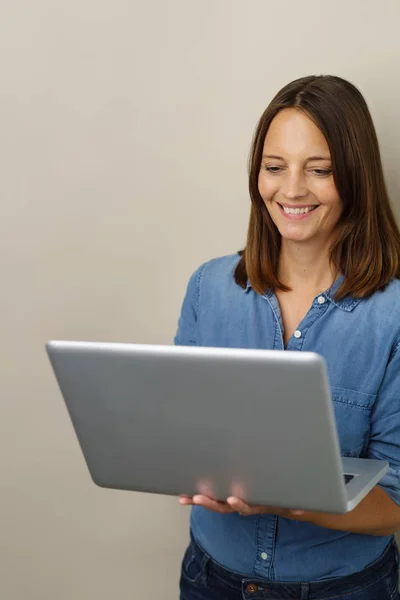 Mulher séria concentrando-se em usar um laptop — Fotografia de Stock