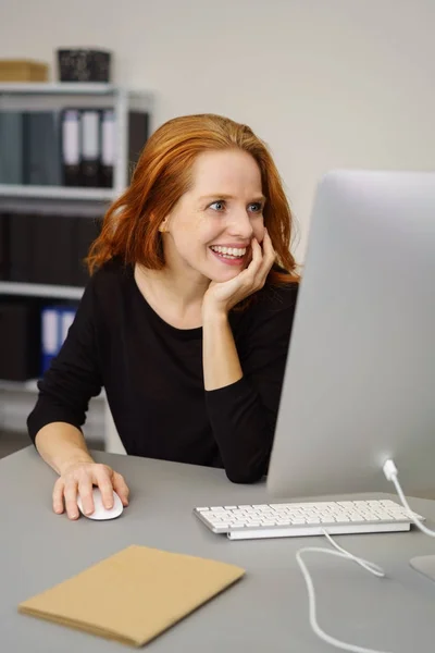 Empresária satisfeita usando monitor de desktop — Fotografia de Stock
