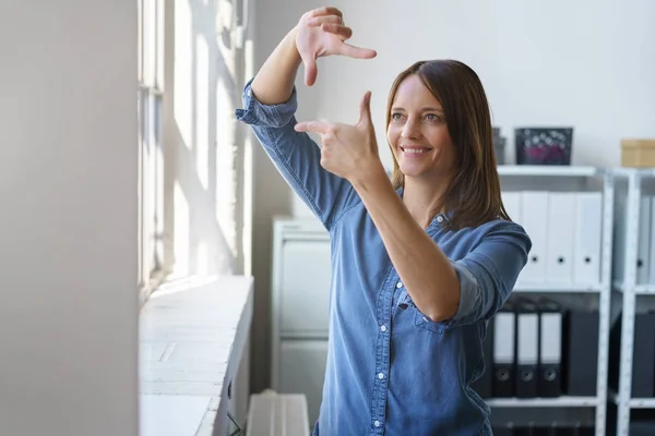 Творческая деловая женщина делает рамку жеста — стоковое фото