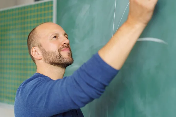 Mannelijke leraar schrijven op blackboard — Stockfoto