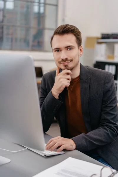 Jovem sentado no computador da mesa — Fotografia de Stock