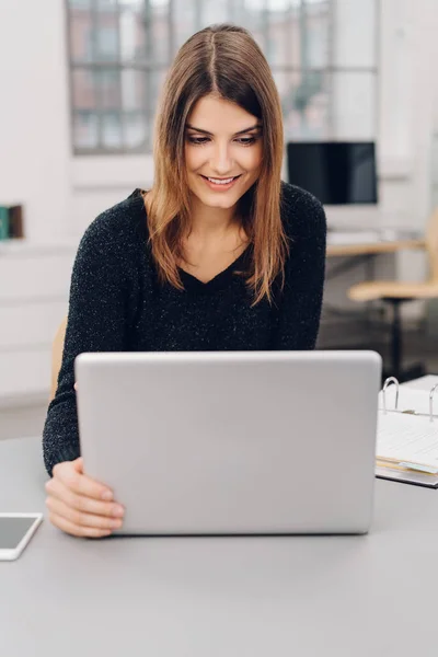 Jovem empresária sorrindo para seu laptop — Fotografia de Stock