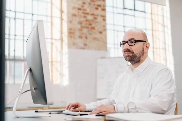 Empresário trabalhando em um grande monitor de desktop — Fotografia de Stock