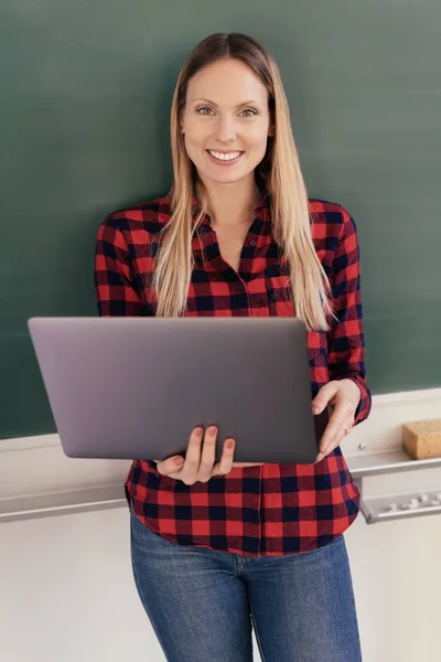 Mujer sonriente de pie con el ordenador portátil — Foto de Stock