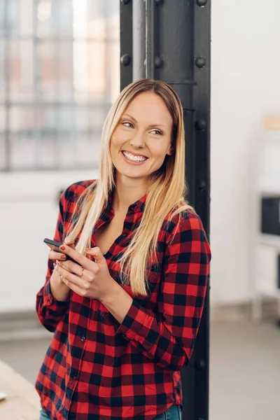 Frau steht mit Handy im Arm — Stockfoto