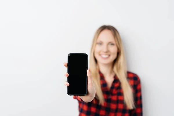 Kvinnan håller ut en mobiltelefon — Stockfoto