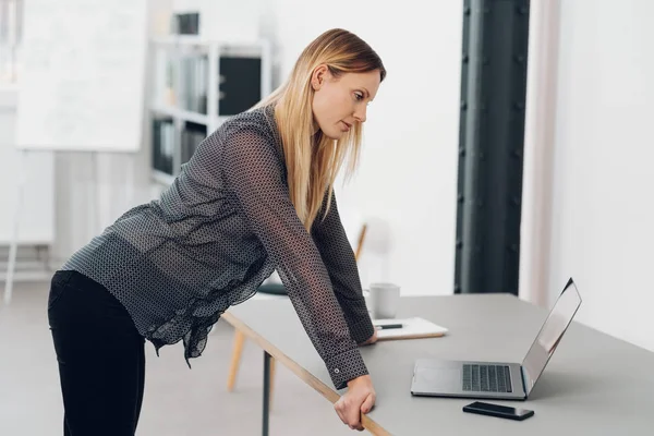 Femme d'affaires penchée sur son bureau — Photo