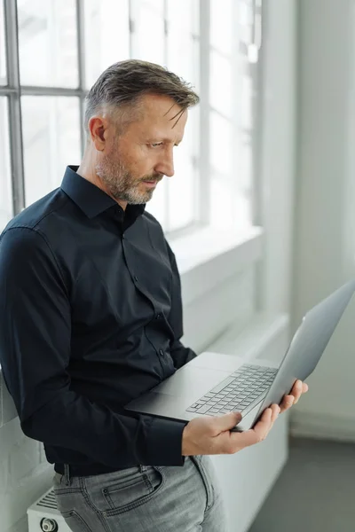 Businessman Using Handheld Laptop Computer Sits Perched Large Radiator Bright — Stock Photo, Image