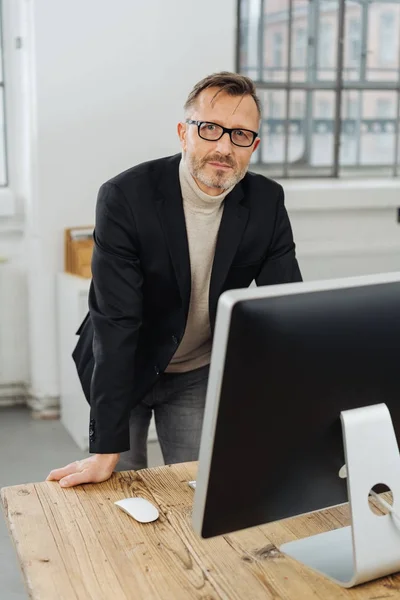 Empresário Sério Apoiando Uma Mesa Escritório Atrás Grande Monitor Computador — Fotografia de Stock