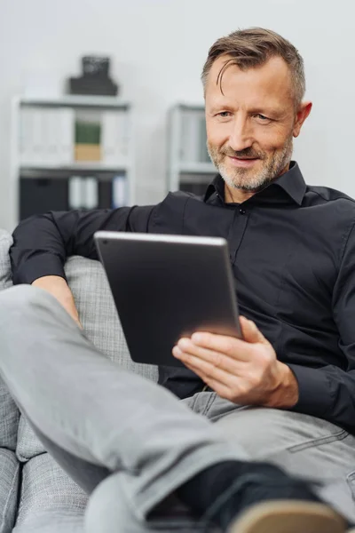 Man Van Vergadering Een Handheld Tabletcomputer Lezen Als Hij Een — Stockfoto