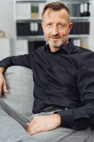 Thoughtful Middle Aged Man Looking Camera Quiet Smile Relaxes Sofa — Stock Photo, Image